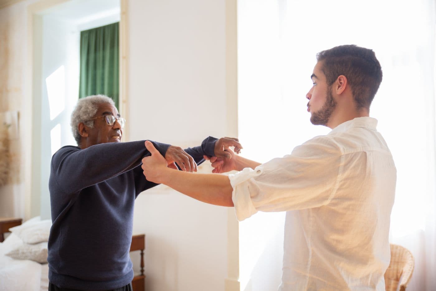 Un aîné accompagné par un soignant lors d'une séance à domicile